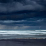It was a cold morning of November. A big storm grew in the Valencian gulf and was approaching quite fast towards the beach. The colour and volume of the clouds were incredible and although there wasn't much lightning I was able to capture one with my camera.
